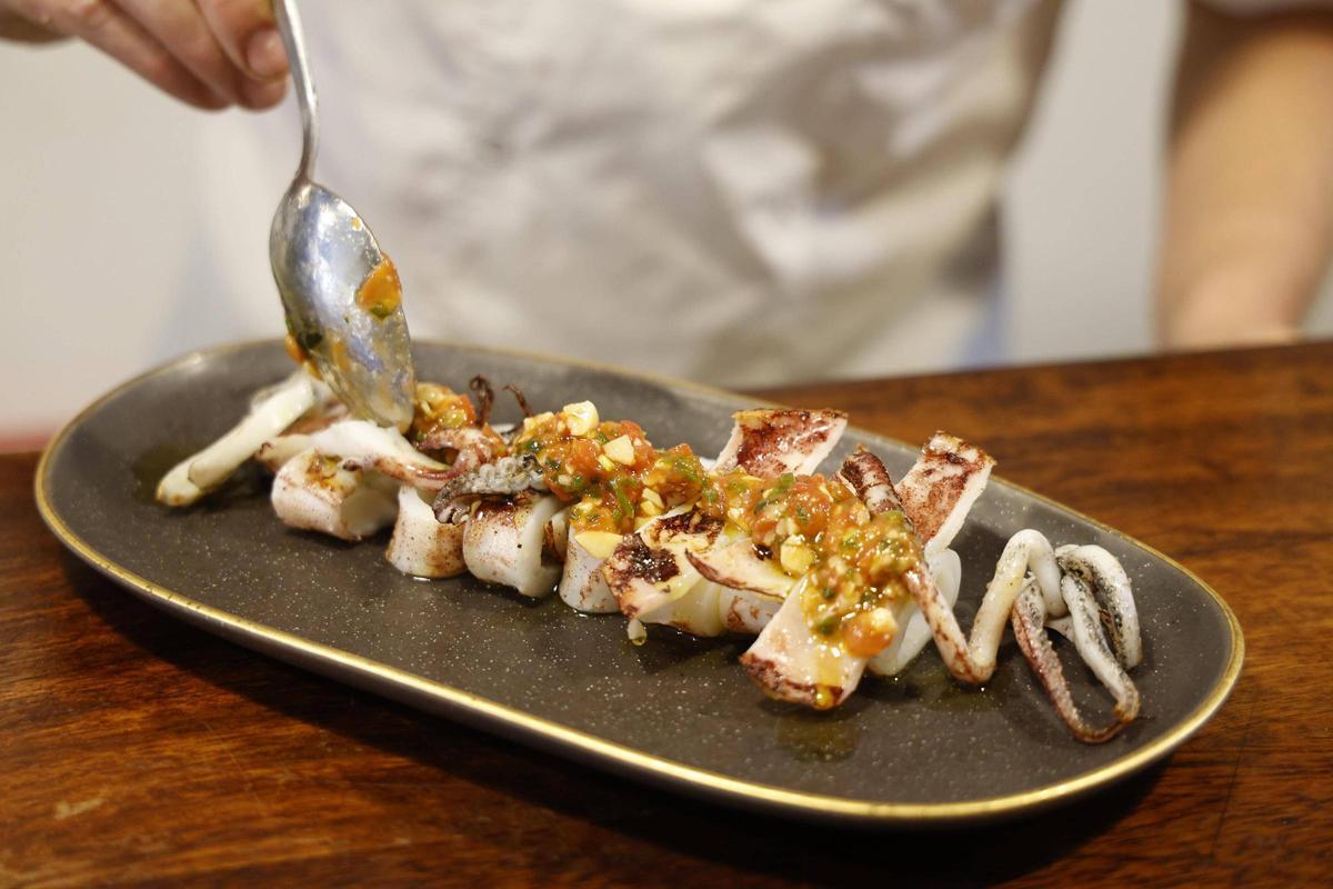 El xef Lluís Vallín preparant un calamar marcat a la planxa amb una vinagreta de tomàquet i estragó.