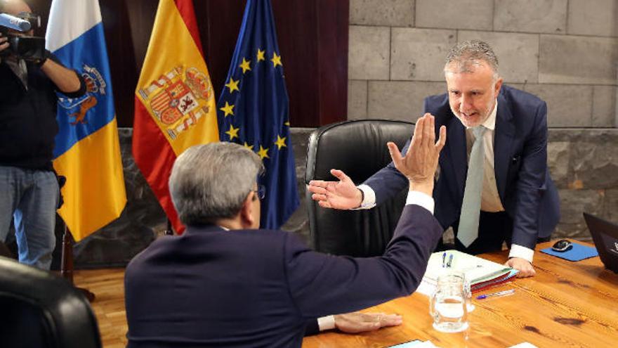 El presidente canario, Ángel Víctor Torres, saluda a su consejero de Hacienda, Román Rodríguez.