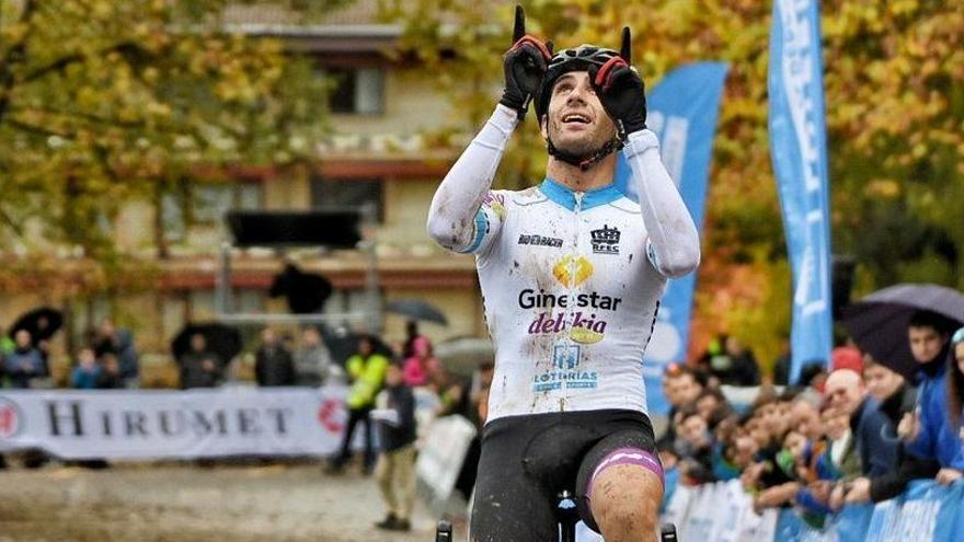 Felipe Orts entra vencedor en la línea de meta con dos de sus dedos indicando al cielo