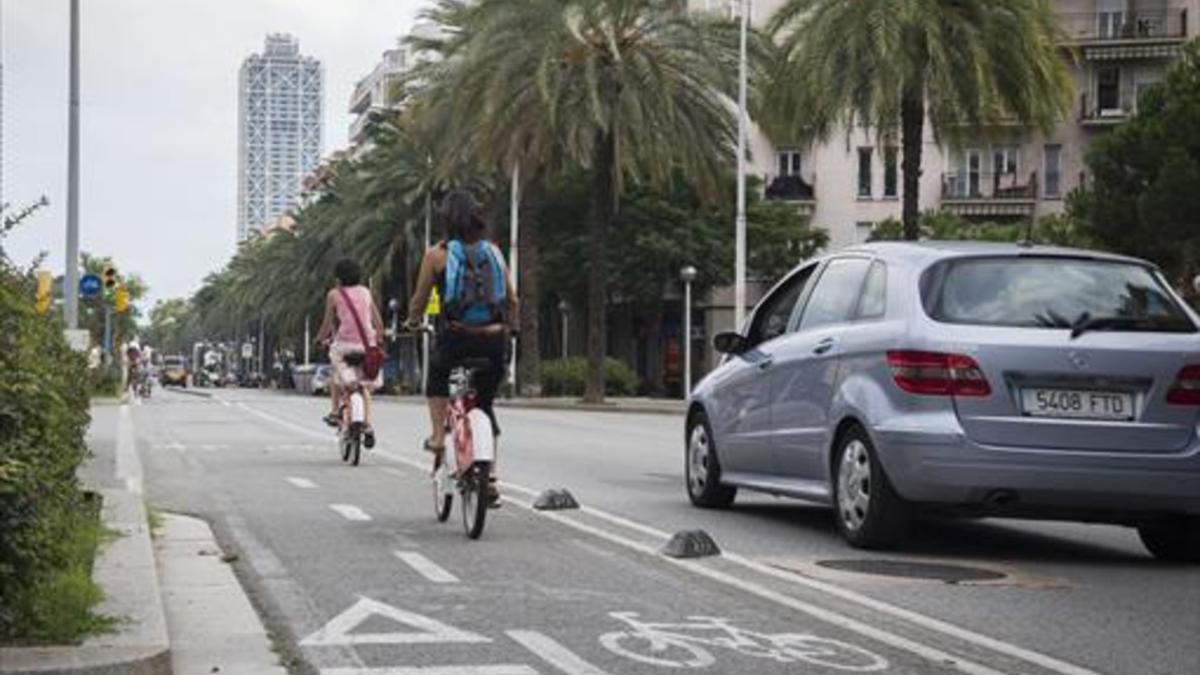 Dos ciclistas circulan por el carril bici de dos direcciones de la calle de Marina.