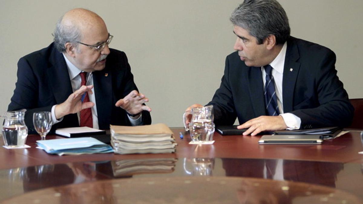 El 'conseller' de Economia, Andreu Mas-Colell (izquierda), habla con el portavoz, Francesc Homs, durante la reunión del Govern.