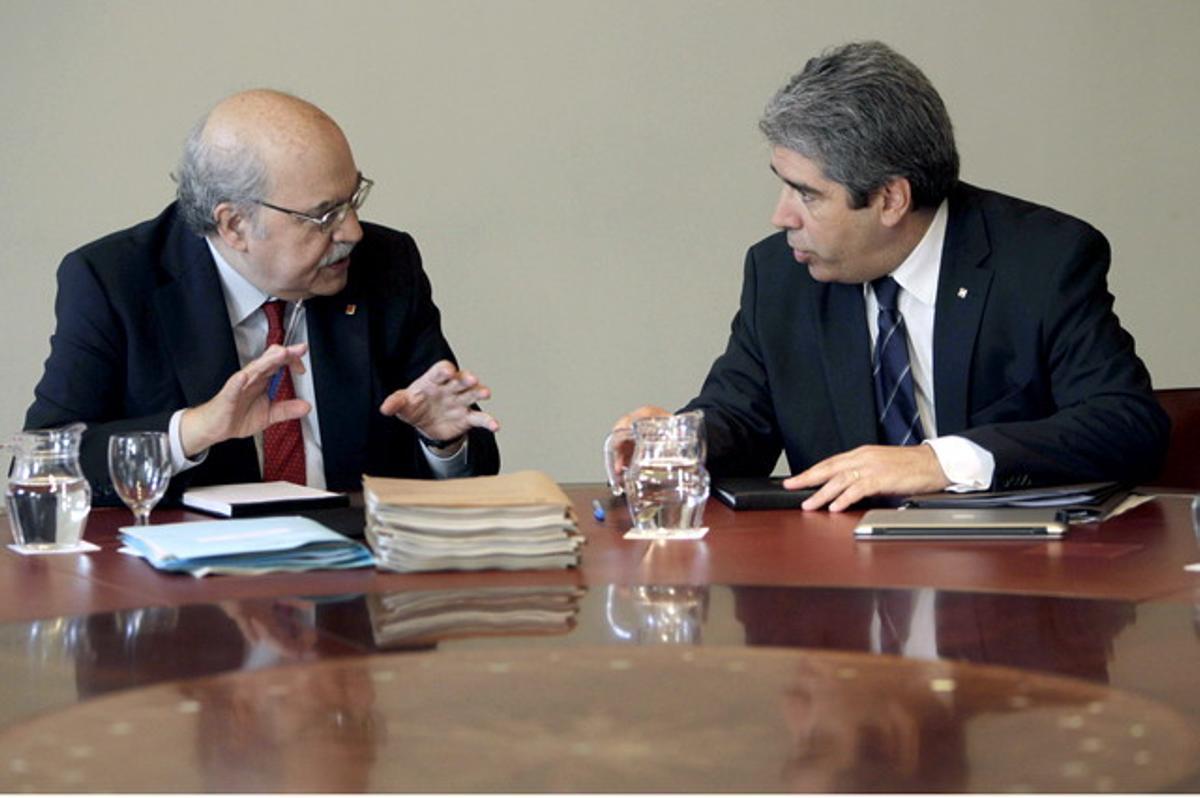 El 'conseller' de Economia, Andreu Mas-Colell (izquierda), habla con el portavoz, Francesc Homs, durante la reunión del Govern.