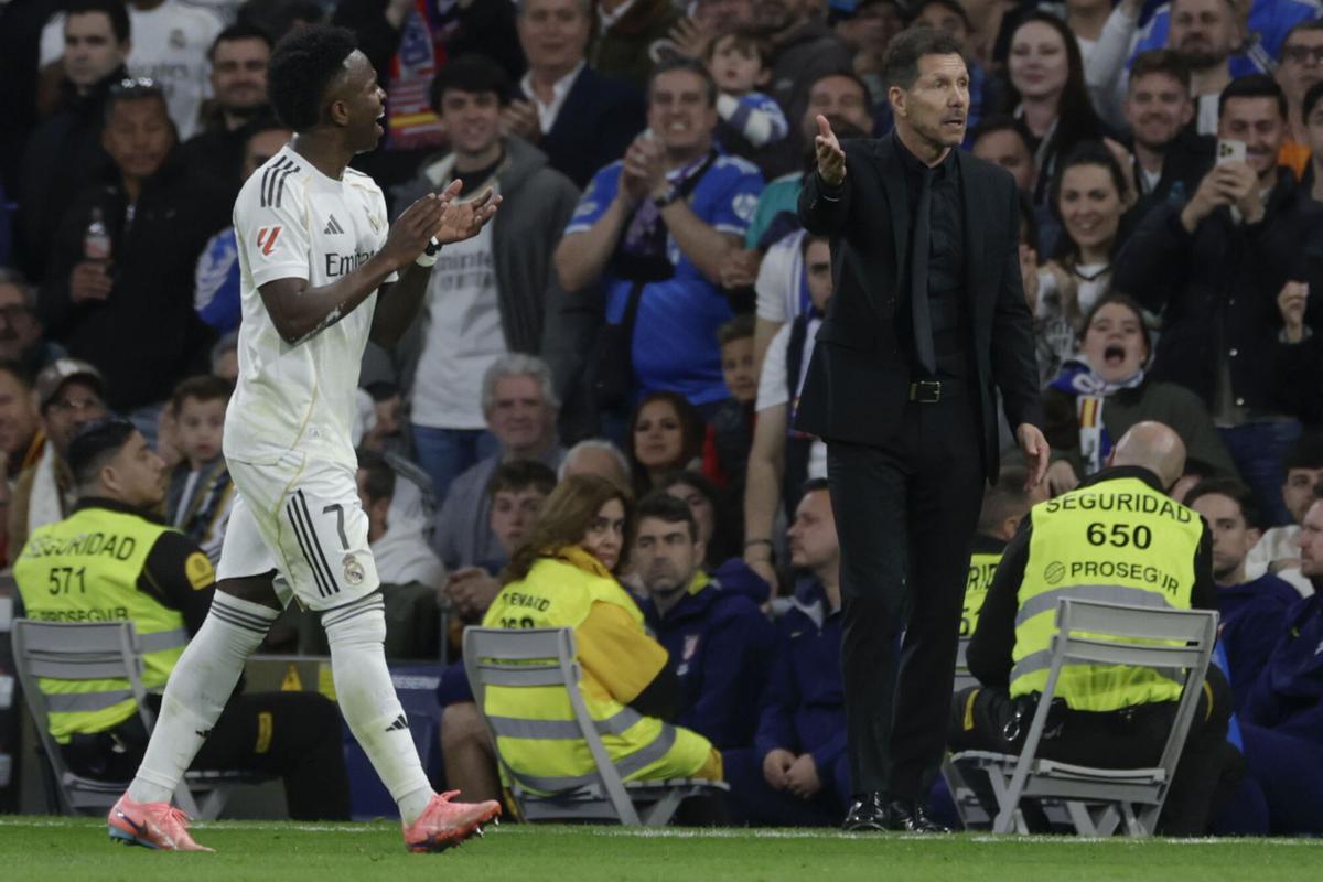 MADRID, 22/03/2026.- El delantero del Real Madrid Vinicius Junior (i) abandona el terreno de juega ante el técnico Diego Simeone, del Atlético, durante el partido de la jornada 29 de LaLiga que Real Madrid y Atlético de Madrid han disputado este domingo en el estadio Santiago Bernabéu. EFE/Juanjo Martín. real madrid . atletico madrid. liga españa 2025/2026 real madrid . atletico madrid. 29. accion. santiago bernabeu