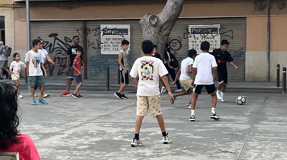 One group of schoolchildren play football, at the exit of the 'Cole', in the Plaza de Santa Elisabet, in Palma.
