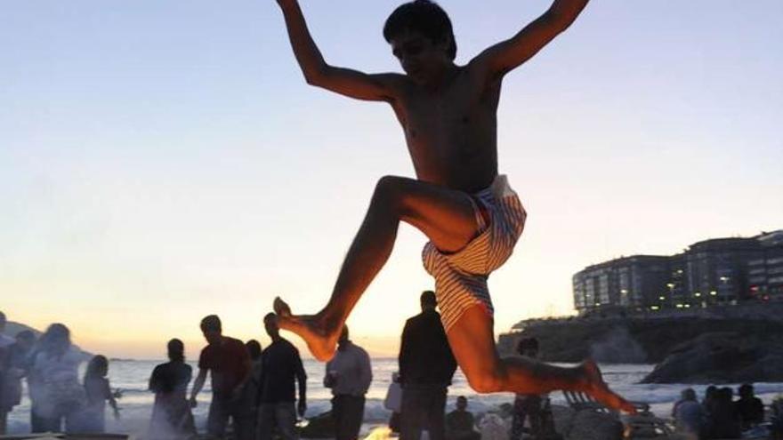 Un joven salta una hoguera de San Juan en una playa de A Coruña. juan varela