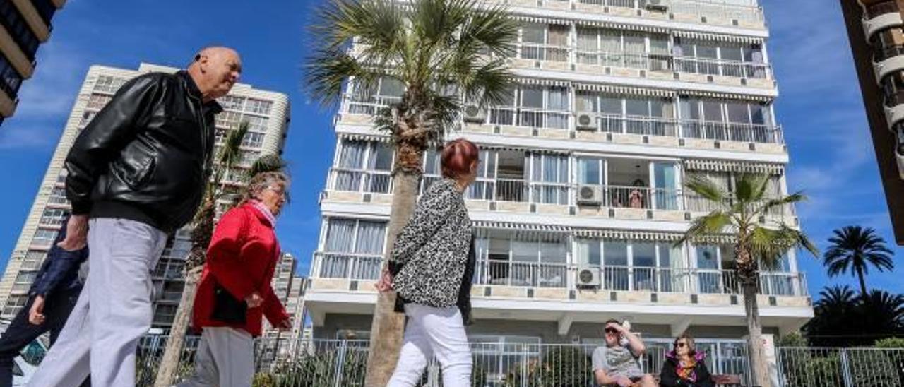 Un grupo de turistas ingleses miran los apartamentos que hay en venta en la ciudad de Benidorm.