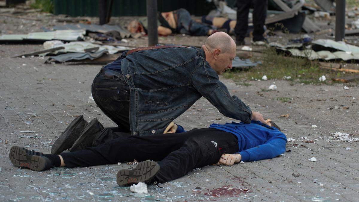 Russias attack on Ukraine continues, in Kharkiv SENSITIVE MATERIAL. THIS IMAGE MAY OFFEND OR DISTURB A man checks the body of his 13 year-old son, who was killed by a Russian military strike, as Russias attack on Ukraine continues, in Kharkiv, Ukraine July 20, 2022. REUTERS/Sofiia Gatilova  SMOUT