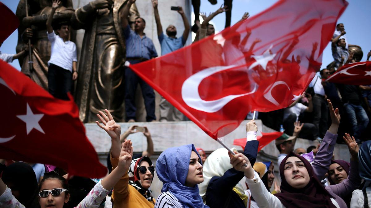 Supporters of Turkish President Tayyip Erdogan shout slogans and wave Turkish national flags during a pro-government demonstration in Sarachane park in Istanbul