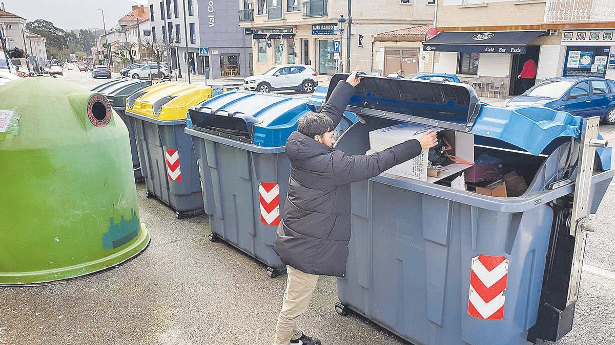 Un joven deposita residuos en el contenedor. | Marta G. Brea