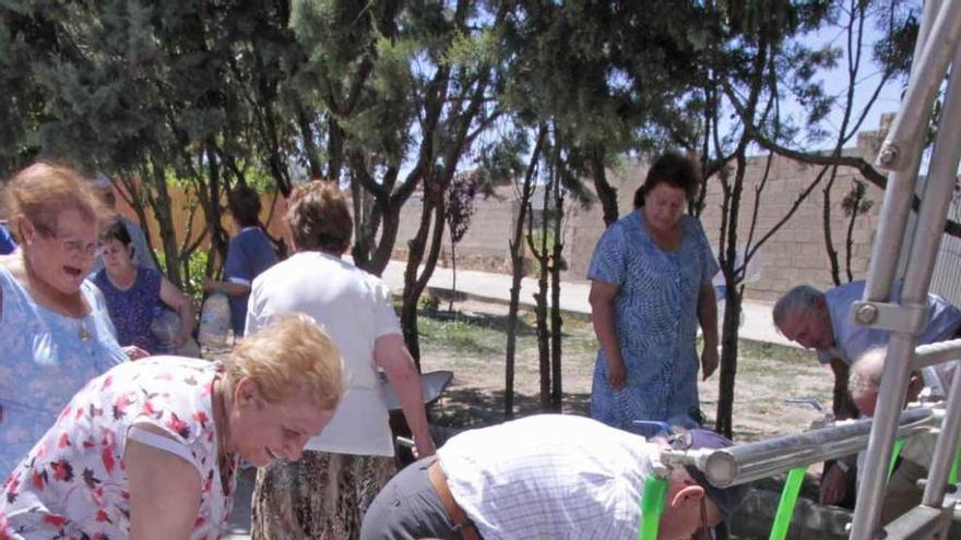 Vecinos de un municipio recogen agua de camiones cisterna.