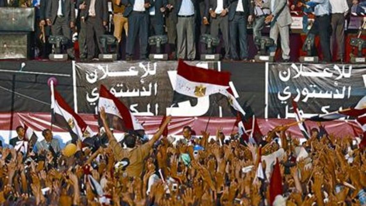Mursi, en el centro del estrado, con los brazos alzados, ayer en la plaza Tahrir de El Cairo.