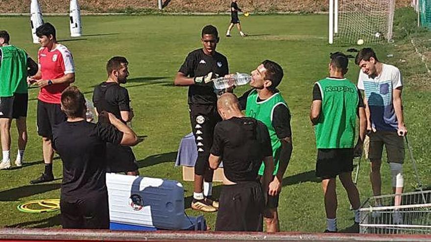 Los jugadores se hidratan en uno de los descansos de la sesión matutina de entrenamientos de ayer.