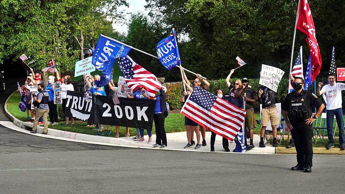 Simpatizantes y detractores de Trump, a la entrada de su campo de golf en Sterling (Virginia).