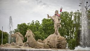 Archivo - La estatua de la fuente de Neptuno, con una bufanda del Atlético de Madrid