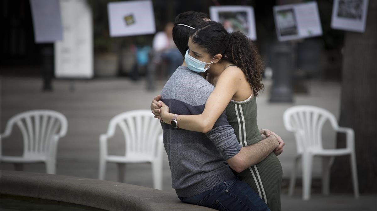 Una pareja se abraza en la plaza Reial.