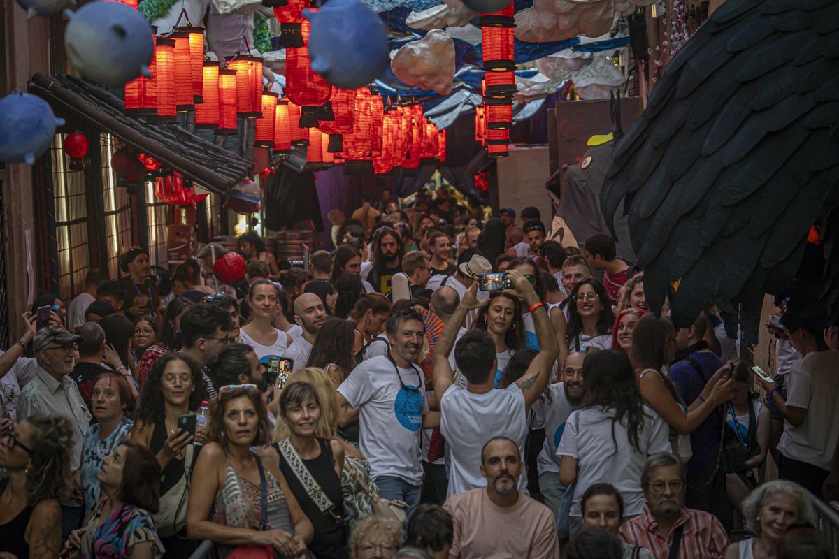 Público bajo las linternas japonesas de la calle Mozart, tras ganar el concurso de calles decoradas de la fiesta de Gràcia, en Barcelona. Público bajo las linternas japonesas de la calle Mozart, tras ganar el concurso de calles decoradas de la fiesta de Gràcia, en Barcelona.