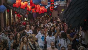 Público bajo las linternas japonesas de la calle Mozart, tras ganar el concurso de calles decoradas de la fiesta de Gràcia, en Barcelona.