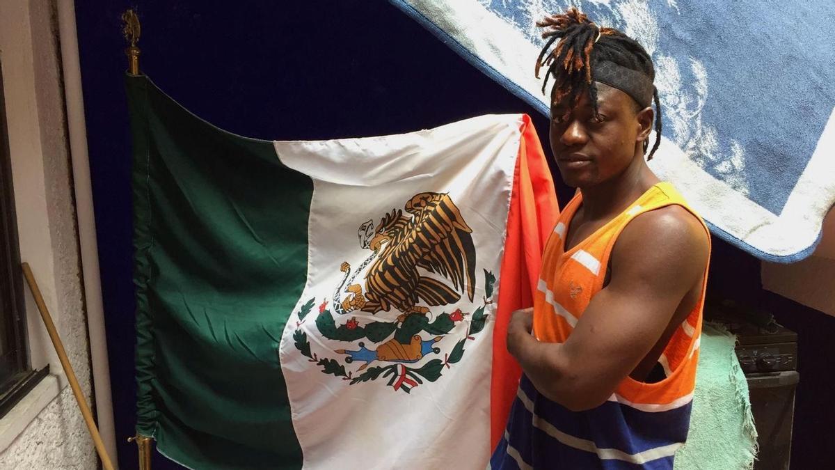  El haitiano Jean Robert Saintilma sostiene una bandera mexicana en Casa Tochán, en Ciudad de México.