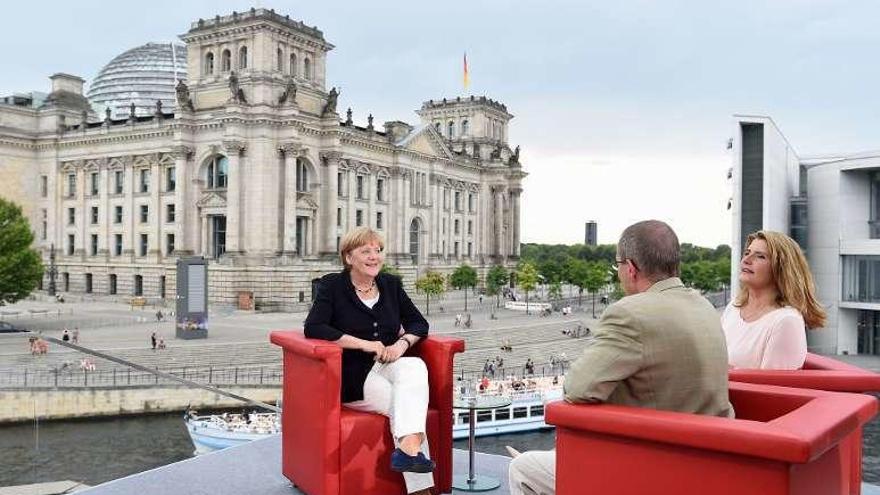 Merkel, con el Bundestag al fondo, durante una entrevista. // Efe