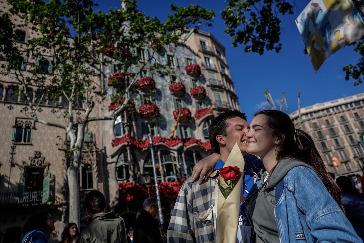 Una pareja con una flor, frente a la Casa Batlló de Barcelona, durante la celebración de Sant Jordi 2024.