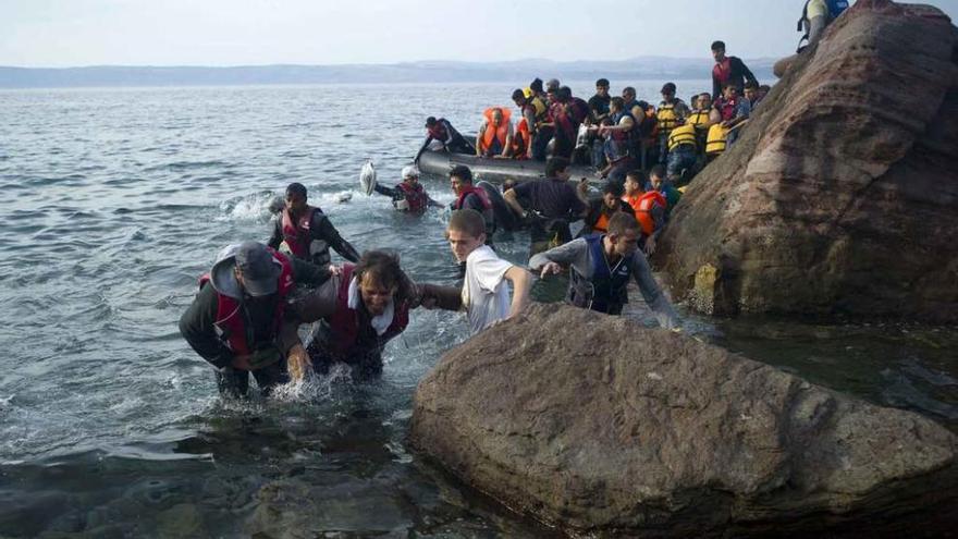 Refugiados sirios tratan de alcanzar la costa tras su travesía por el mar Egeo en la isla de Lesbos.