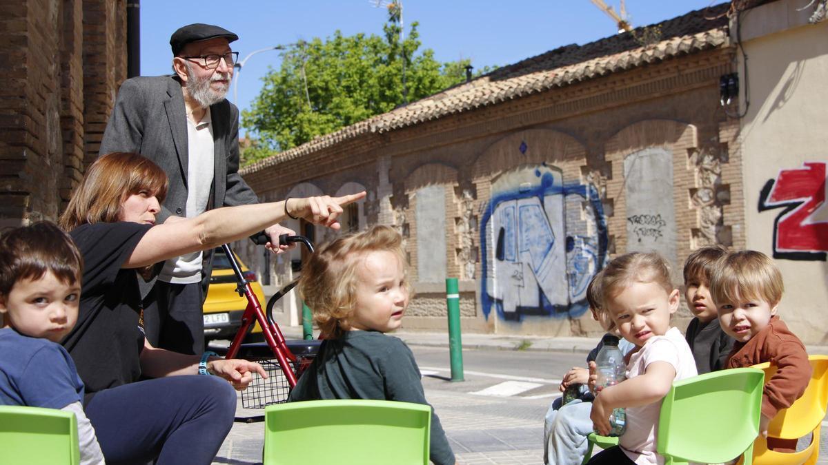 El poeta Marc Granell i la mestra Amparo Campos, junt amb la xicalla, davant les casetes obreres centenàries de Patraix.