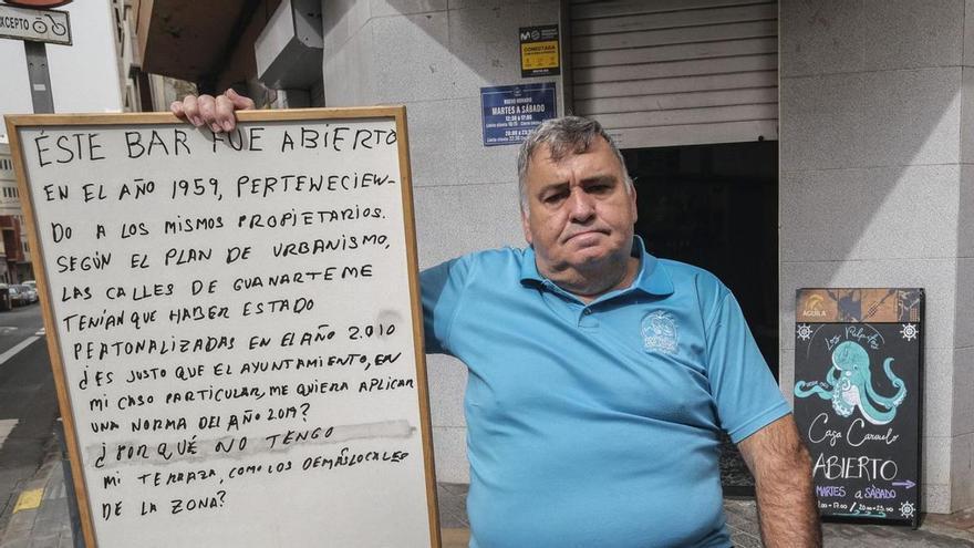 Luis Díaz con su cartel de protesta en la puerta del bar Casa Carmelo