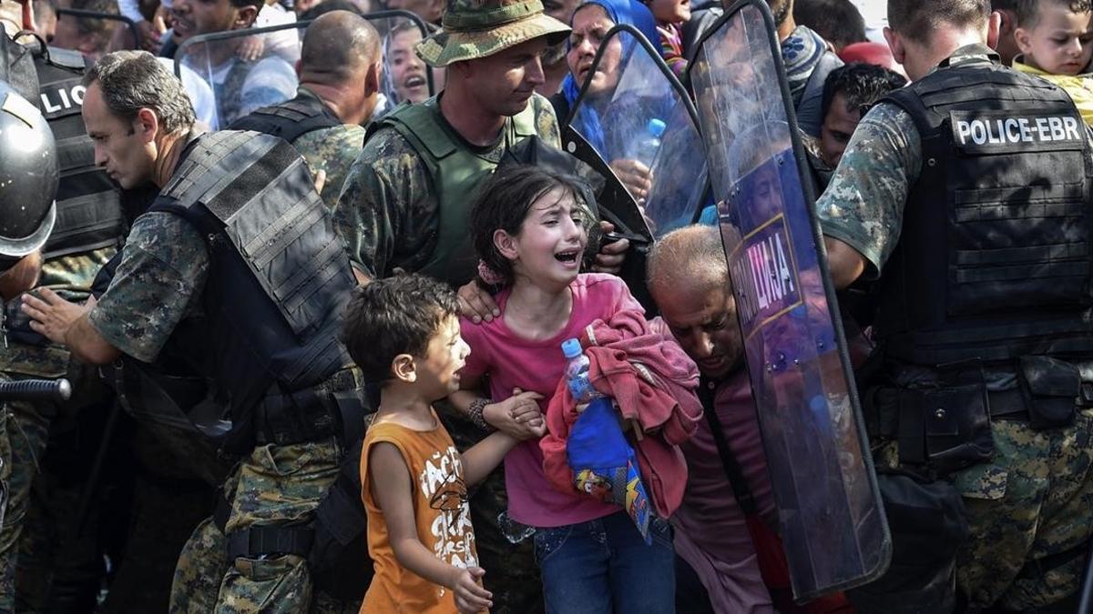 Dos niños lloran en un enfrentamiento entre inmigrantes y policía en la frontera de Grecia y Macedonia, en el 2015.