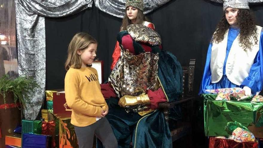 Una niña le cuenta sus deseos de Navidad al Príncipe Aliatar, ayer, en Ribadesella.