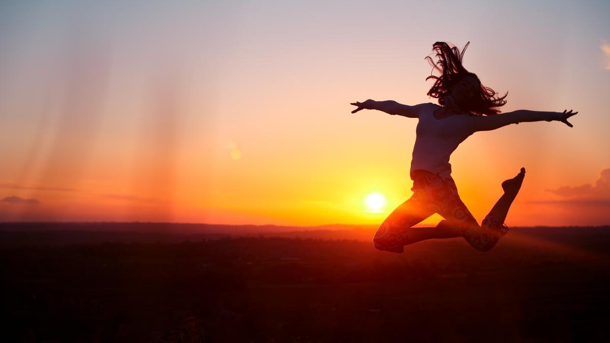 Una persona se suspende en el aira tras dar un salto durante una puesta de sol.