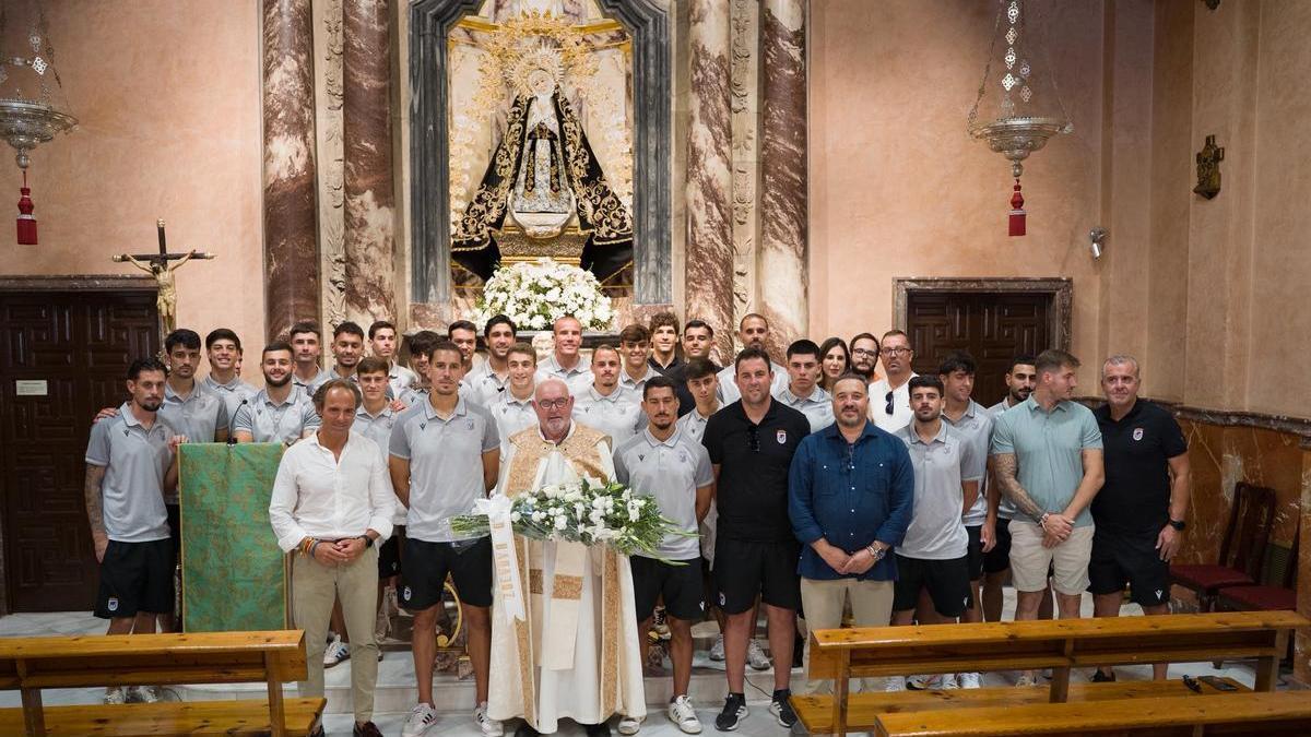 Plantilla, cuerpo técnico y directiva del Badajoz junto a la Virgen de la Soledad.