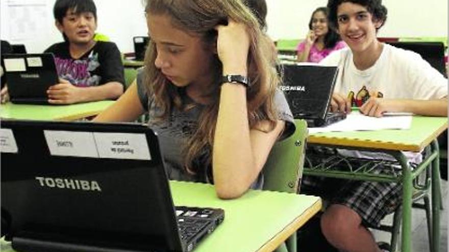 Alumnes amb els ordinadors portàtils a l&#039;aula, en una imatge d&#039;arxiu.