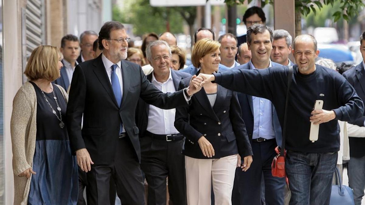 El candidato del PP, Mariano Rajoy, acompañado de María Dolores de Cospedal, es saludado por un simpatizante en Guadalajara, el 17 de junio.