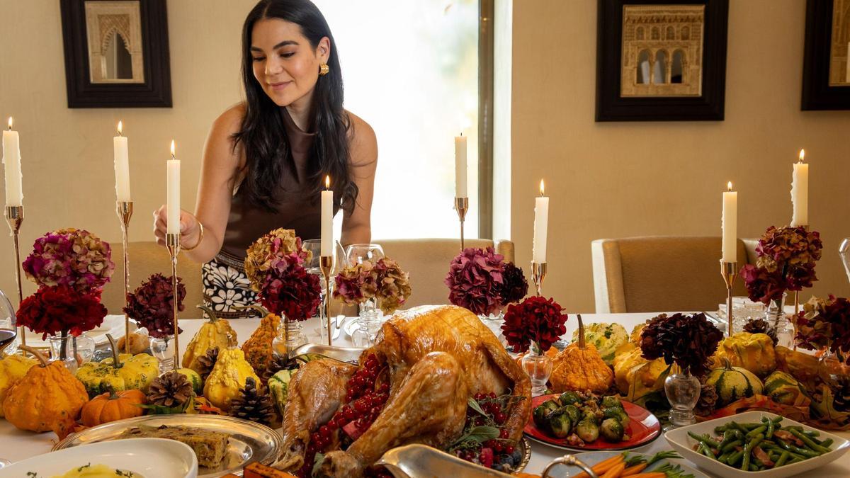 Una mesa navideña engalanada con velas.