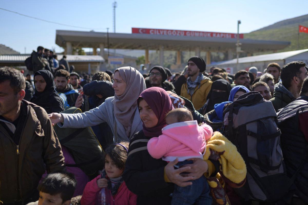 Los residentes sirios de la ciudad de Hatay esperan para cruzar la frontera entre Turquía y Siria después de que se vieron afectados por el terremoto de magnitud 7,8 que asoló la región hace casi dos semanas, en la puerta fronteriza de Cilvegozu