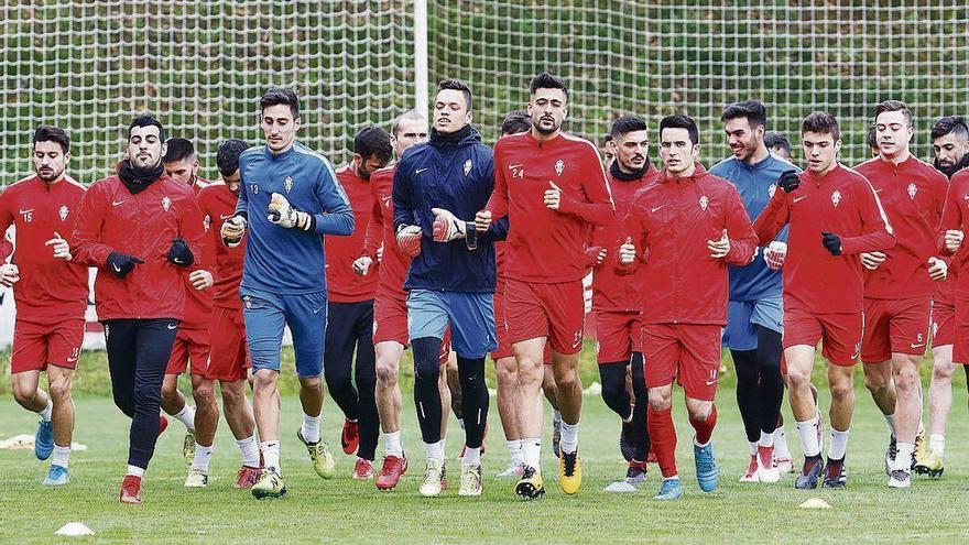 Los jugadores del Sporting realizan ejercicios de calentamiento durante el entrenamiento de ayer.