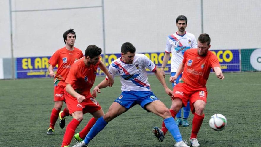 Claudio trata de controlar el balón ante los jugadores del Colunga Busta, a su izquierda, y Sergio.