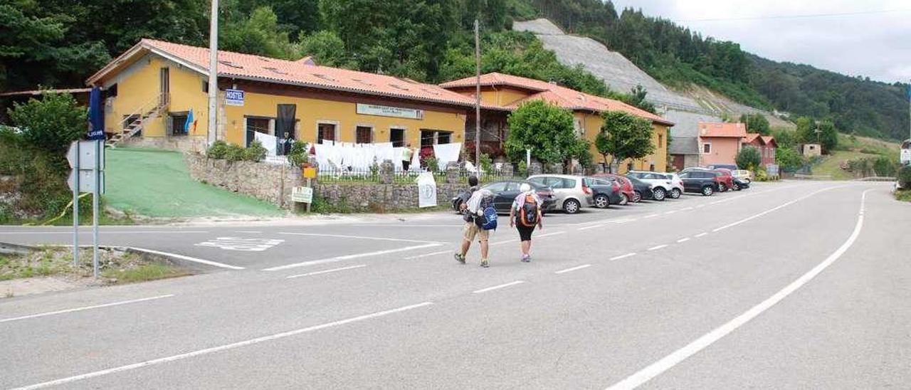 Dos peregrinos cruzan la N-634 a su paso por Buelna (Llanes).