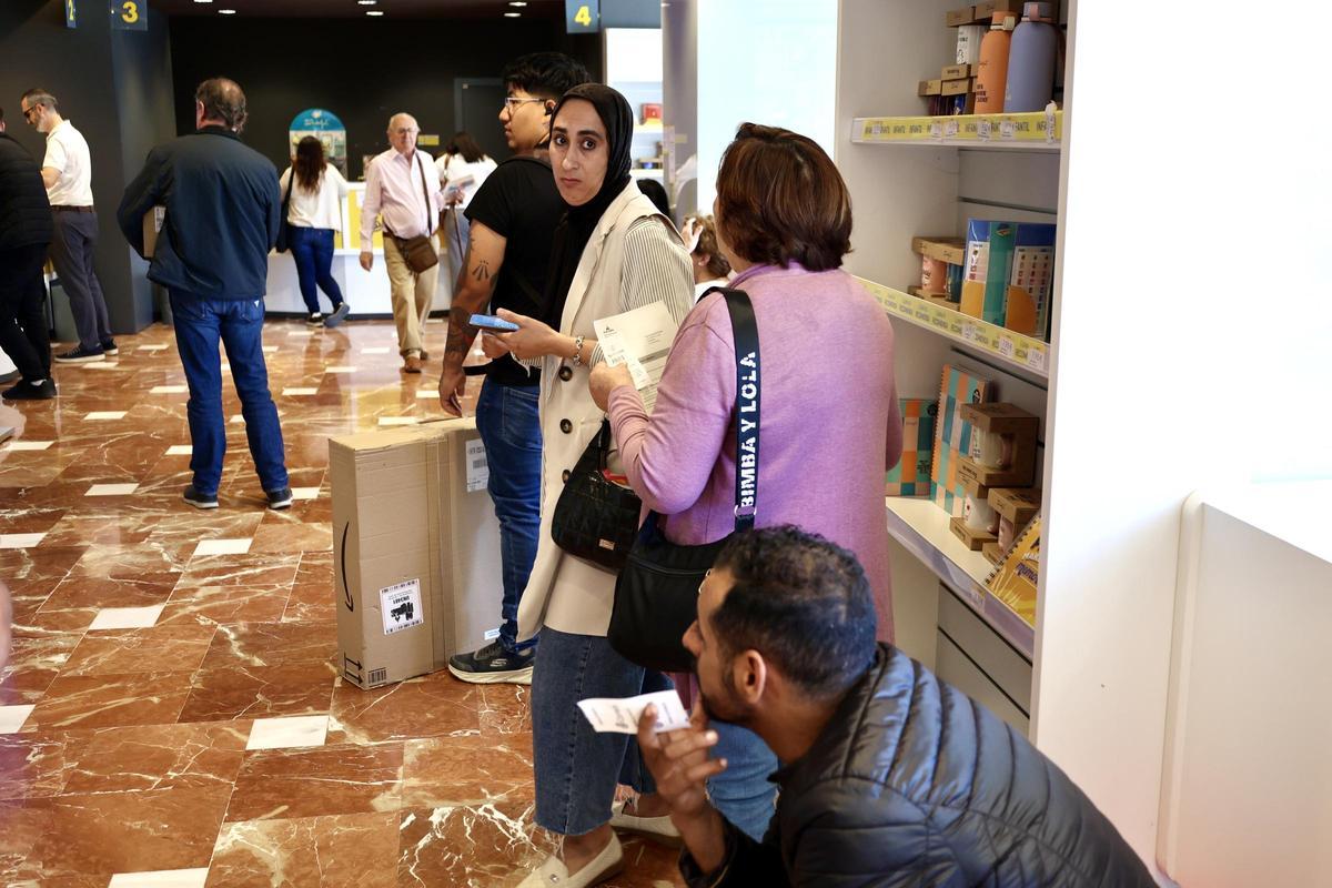 Migrantes este lunes esperando a ser atendidos en el interior de la oficina de Correos de la Plaza Circular de Murcia.