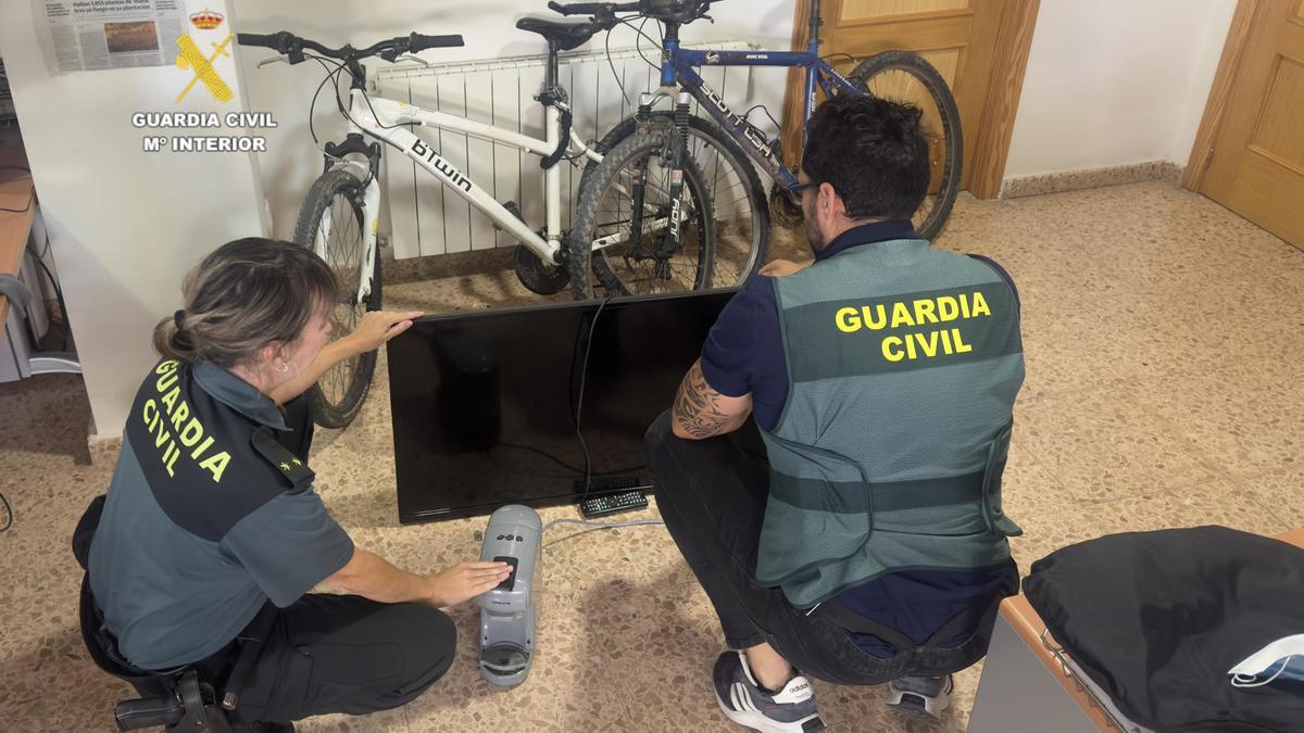 Imagen de dos guardias, con enseres recuperados.