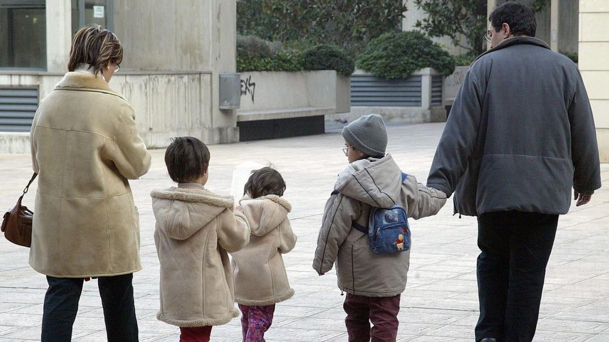 Imagen de archivo de una pareja paseando con tres niños.