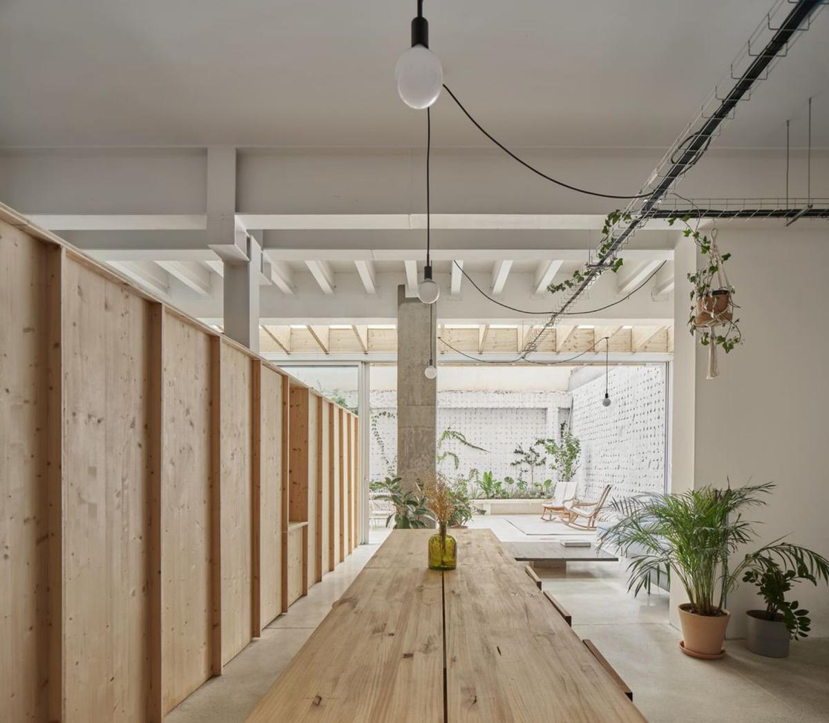 Zona de comedor, a un lado del mueble lineal de madera, y uno de los dormitorios. | JOSÉ HEVIA