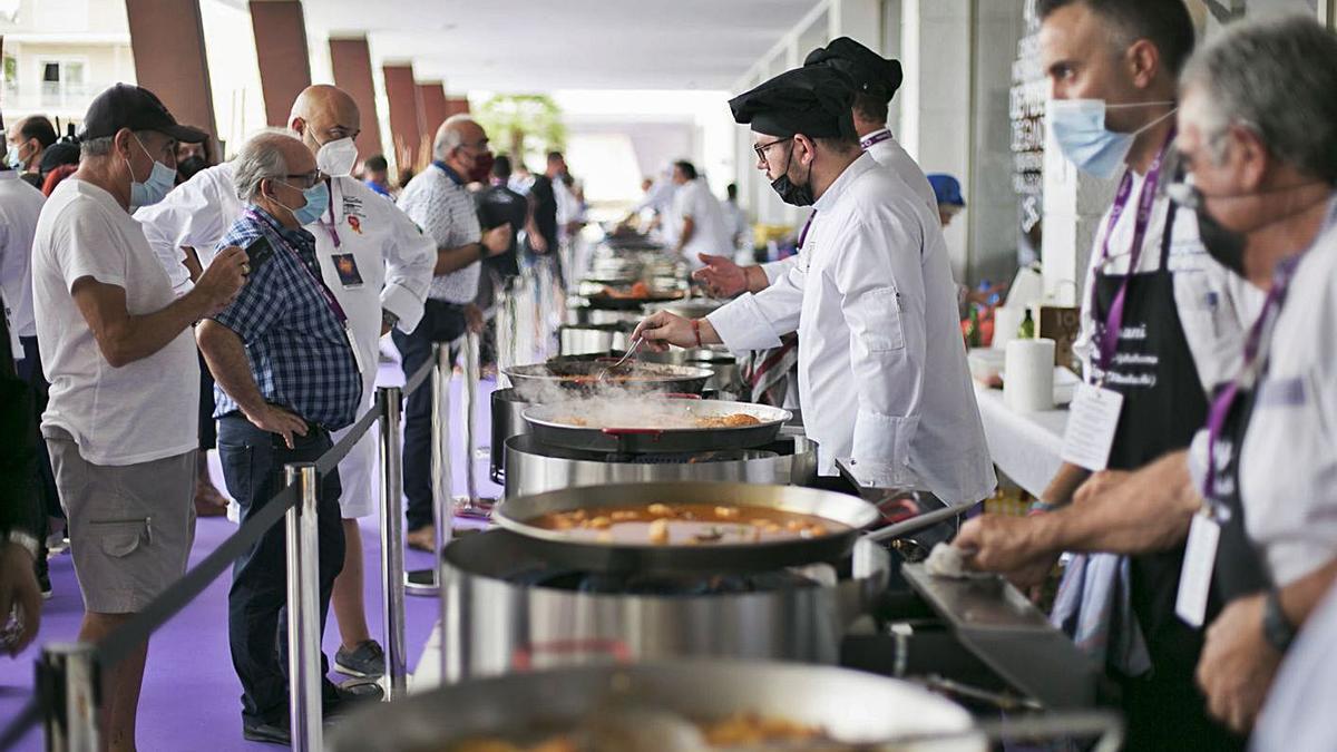 Un momento de la elaboración de las fideuaes por parte de los chefs inscritos y, a la derecha, el alcalde con el dueño y la cocinera del restaurante Casa Granero de Serra.                       | ÀLEX OLTRA