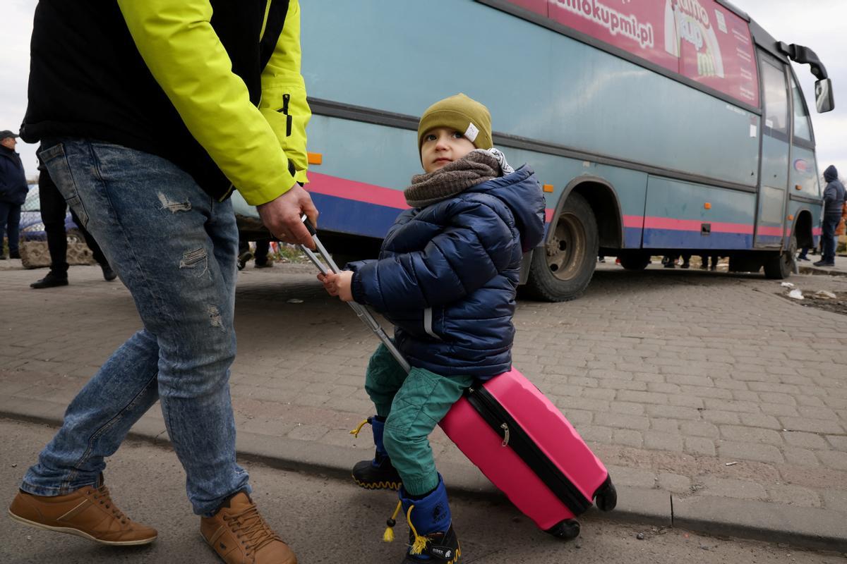 Un niño sobre una maleta, tras llegar a Medyka (Polonia) en autobús, procedente de Ucrania.