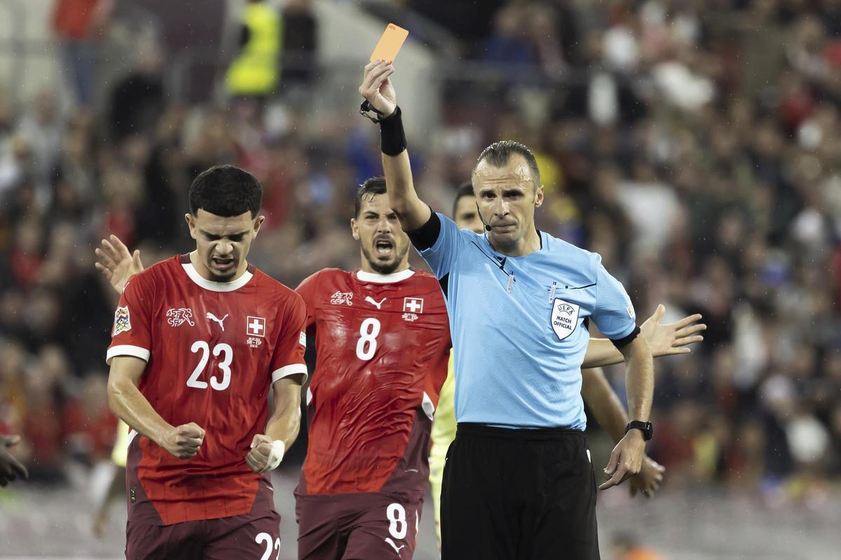 El colegiado del Suiza-España, el bosnio Irfan Peljto, muestra la cartulina roja a Le Normand.