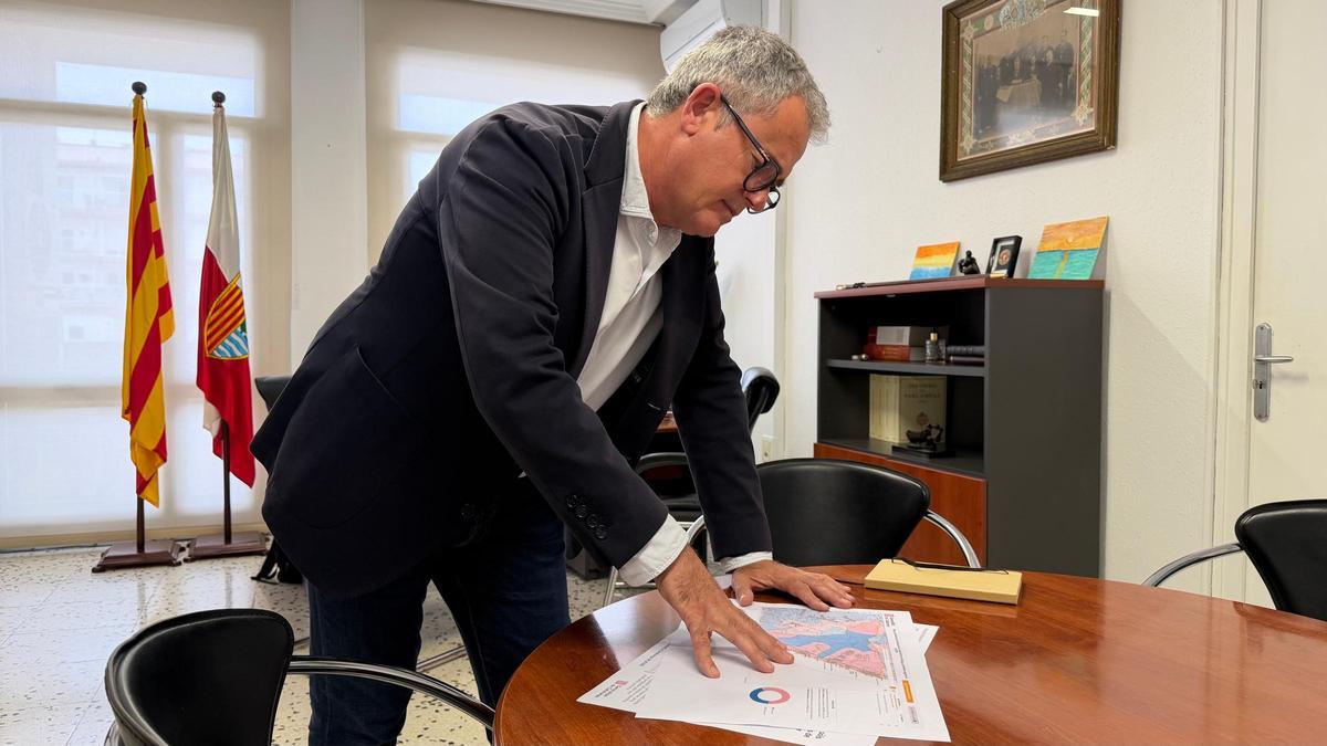 L'alcalde de l'Ametlla de Mar, Jordi Gaseni, mirant el mapa del PLATER al municipi al seu despatx