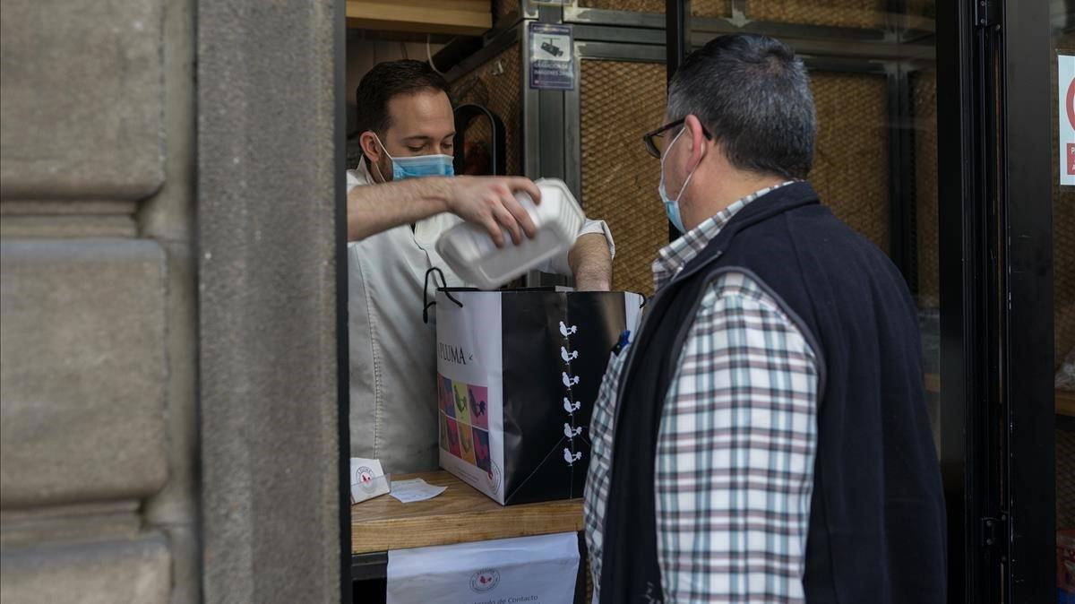 Un cliente recoge un pollo para llevar en A Pluma.