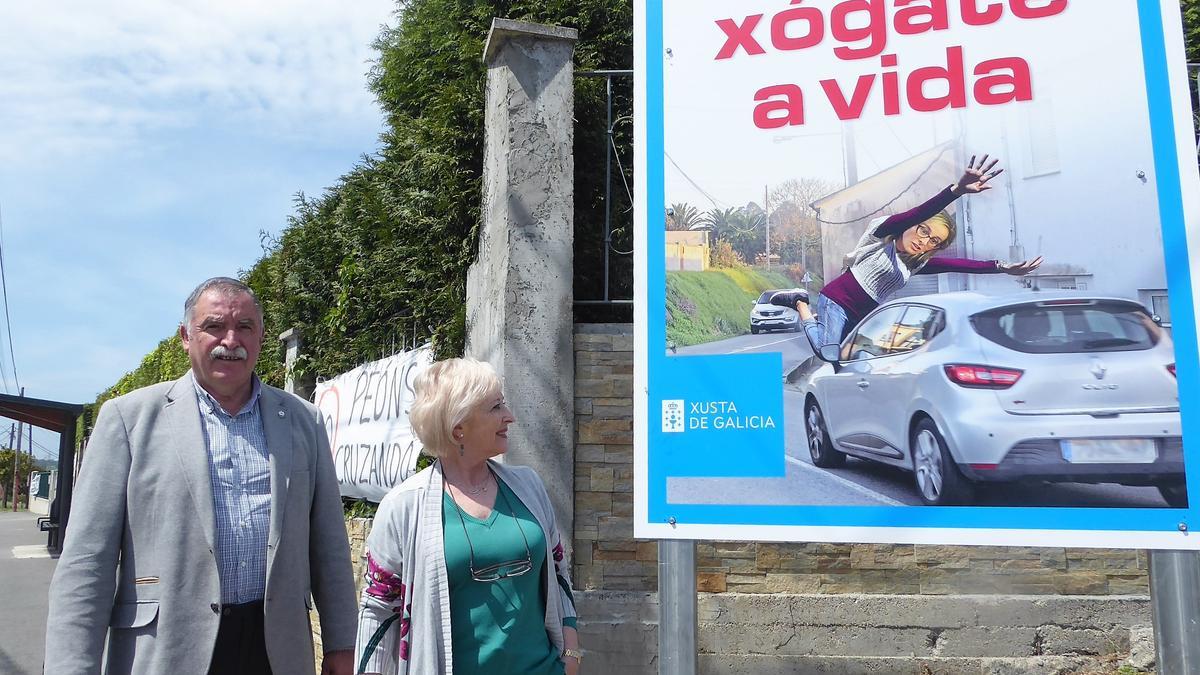 El regidor y la primera teniente de alcalde de Oleiros, ayer ante uno de los carteles en O Couto