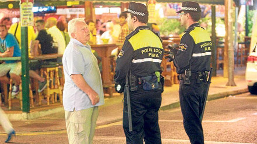 Dos agentes de la Policía Local conversan con un turista en la Playa de Palma.