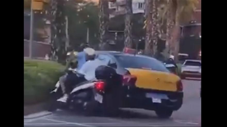 Moment en què el taxi envesteix una moto, amb un menor d&#039;acompanyant.